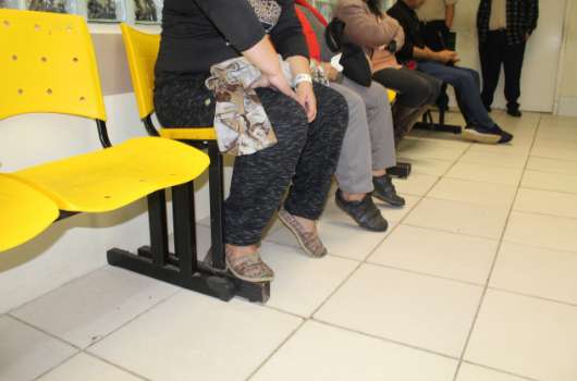 Pessoas aguardam atendimento na sala de espera da Unidade. 